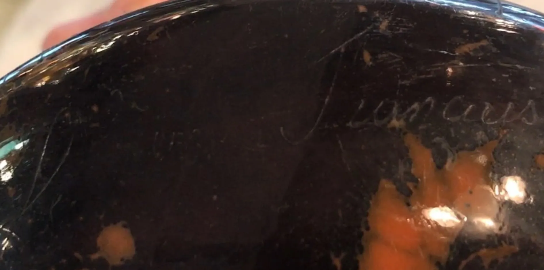 Vidro antigo assinado Le Verre, detalhes visíveis na superfície.