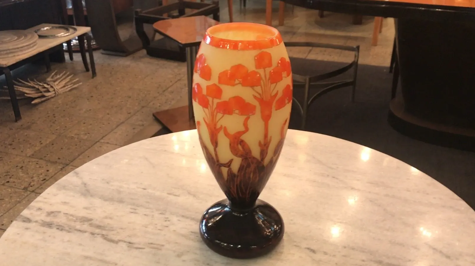 Vaso antigo com decoração floral em tons quentes.