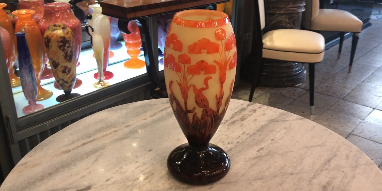 古董签名玻璃花瓶，装饰有花朵。色彩背景。