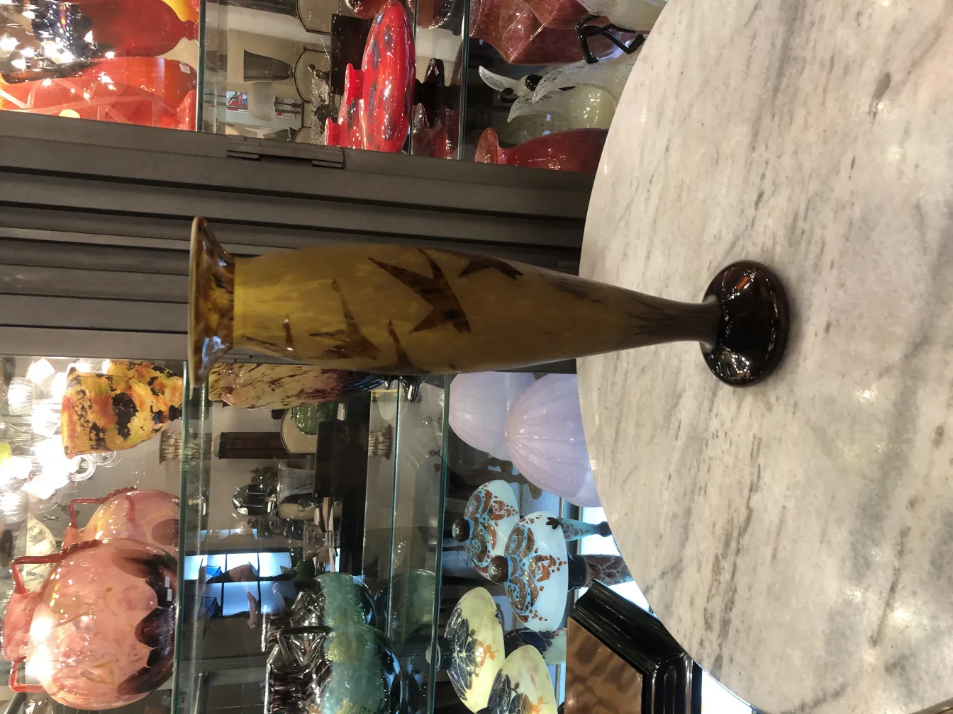 Verre signé antique avec des détails décoratifs jaunes.