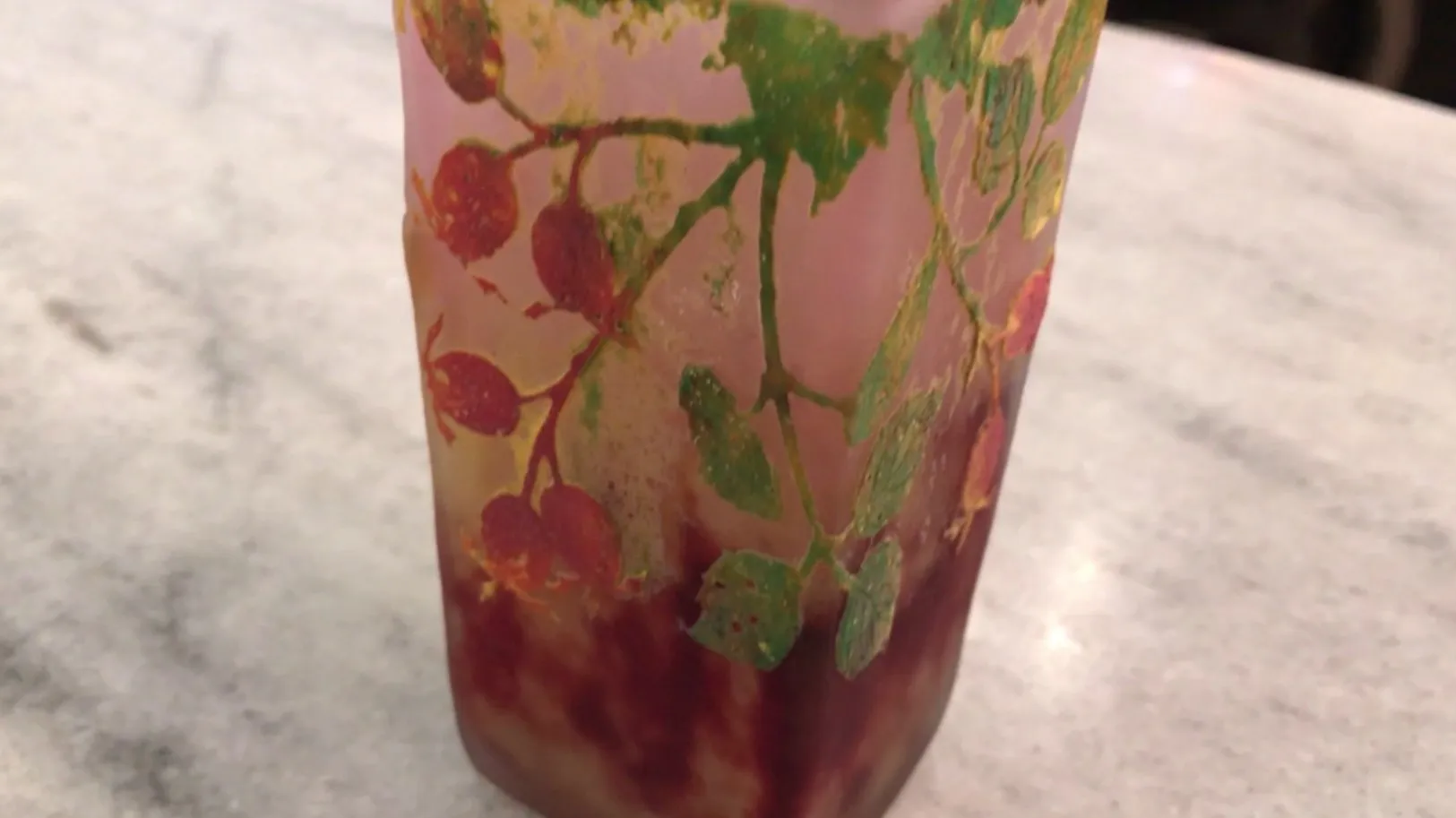 Antikes Glas mit Blatt- und Fruchtdekorationen in warmen Tönen