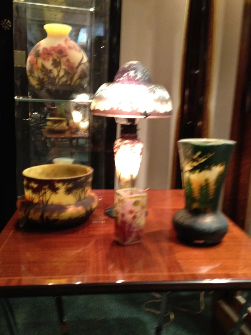 Vidro assinado Daum Nancy com design floral em um ambiente de antiguidade.