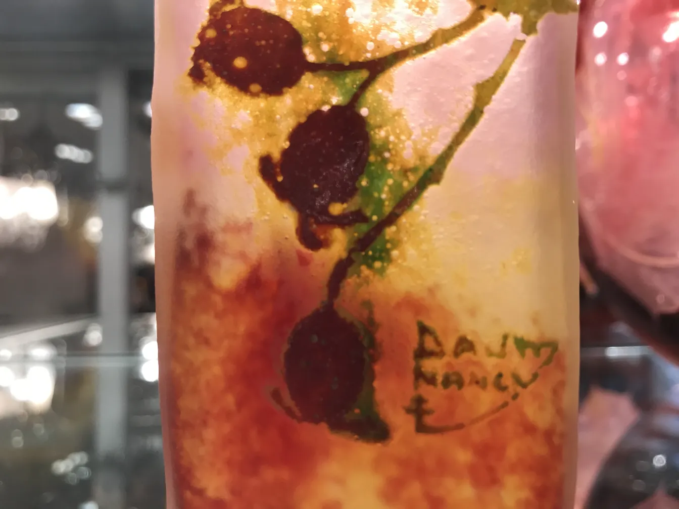 Vidro assinado Daum Nancy com decorações florais em tons quentes, ambiente antigo.