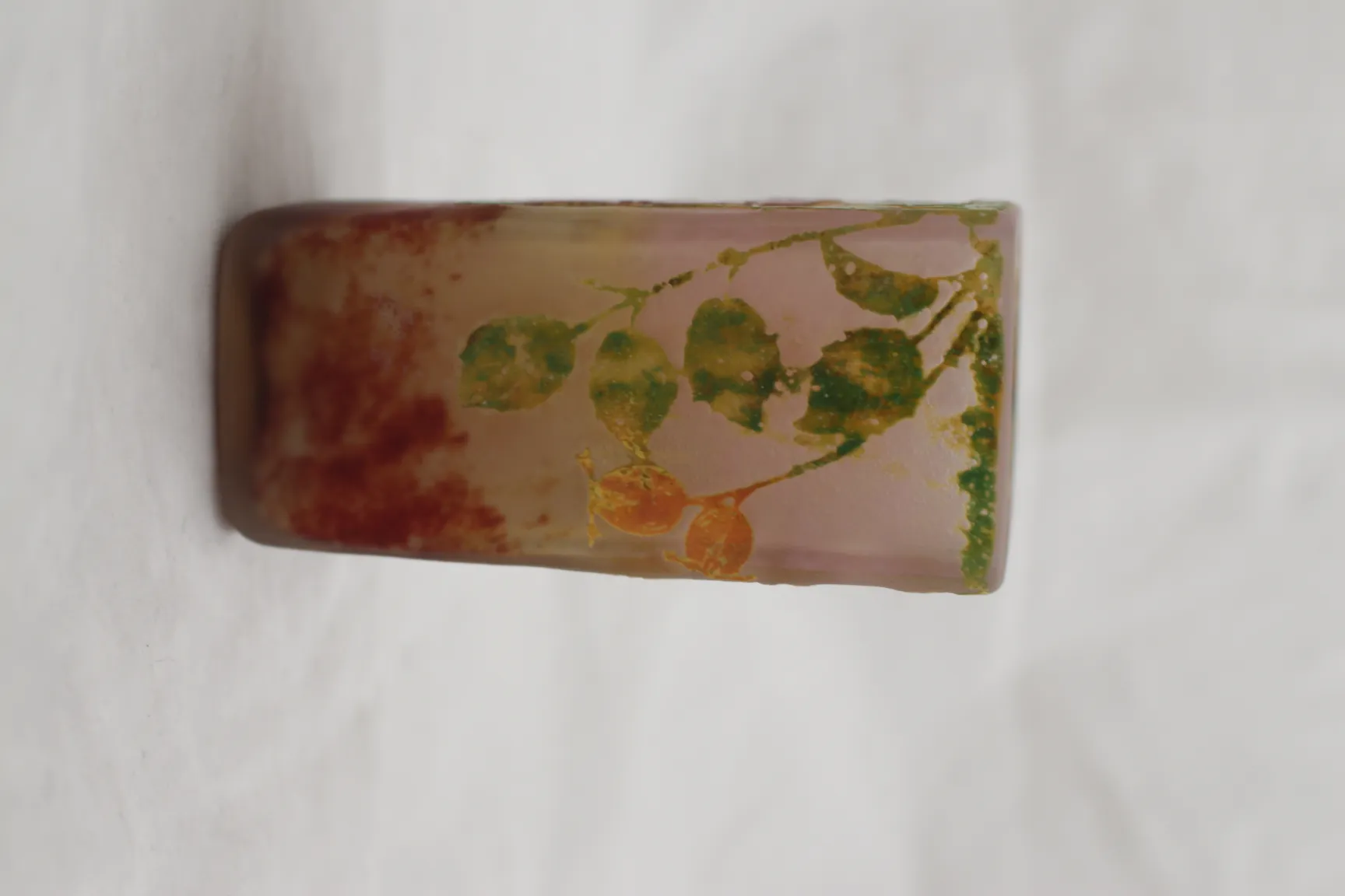 Verre signé Daum Nancy avec design décoratif et couleurs douces sur fond clair.