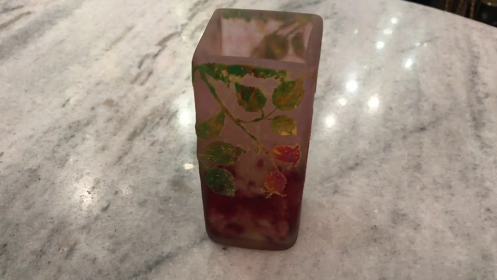 签名玻璃达姆南希，上面有生动颜色的装饰性叶子，放在透明表面上