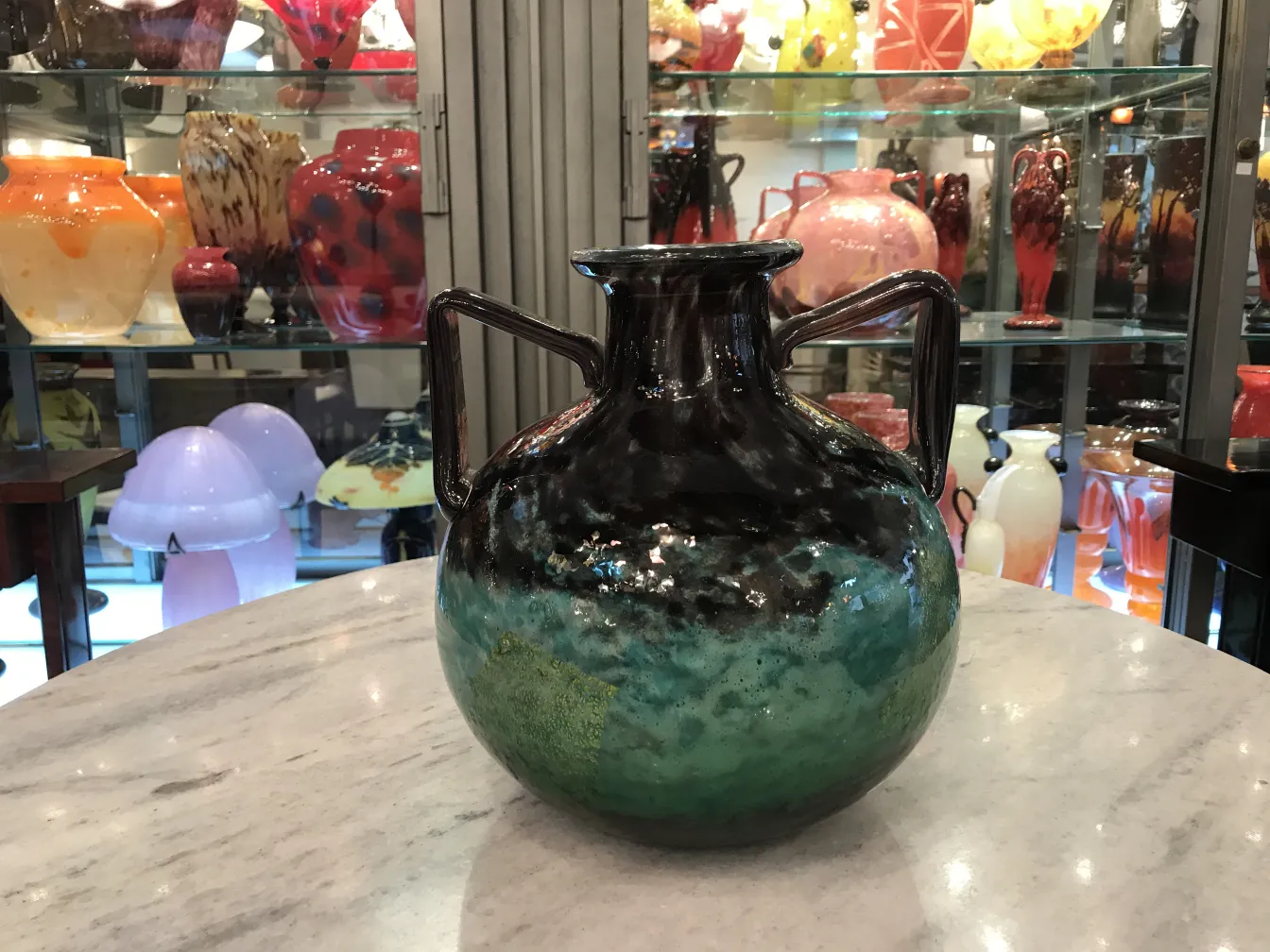 Antique vase signed Daum Nancy with vibrant colors in an antique setting.