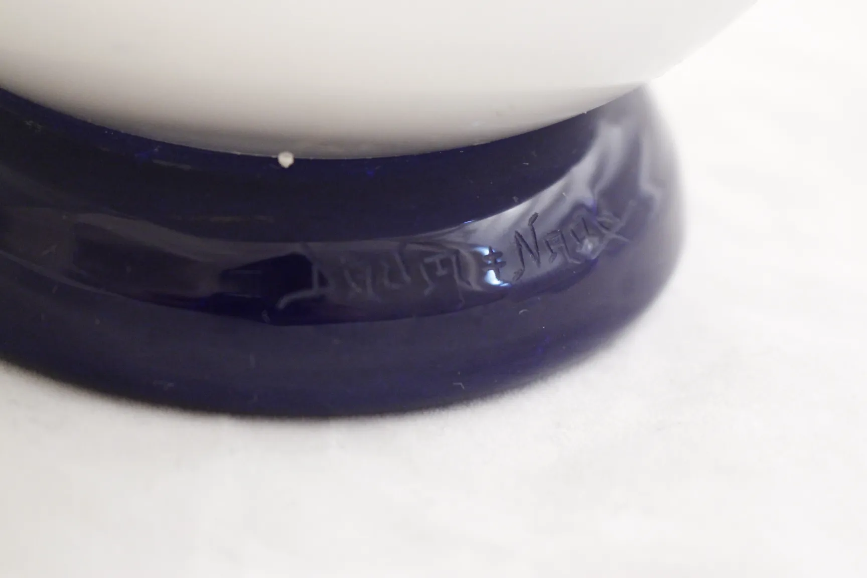 Détail d'une ancienne pièce en verre signé Daum Nancy sur fond clair.