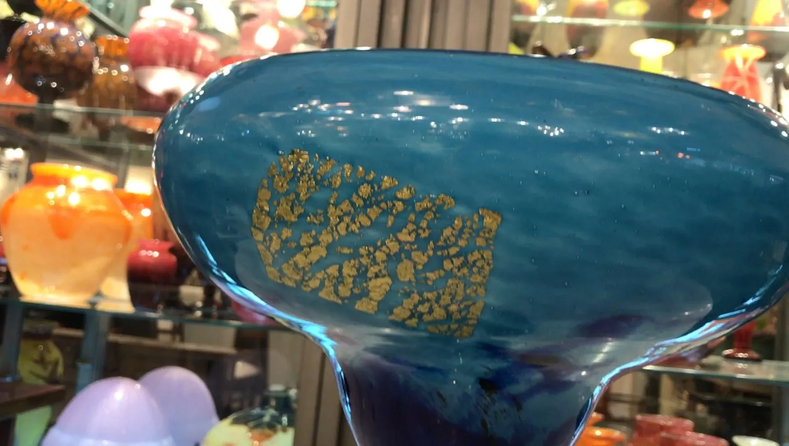 signed glass featuring decorative details in blue and gold