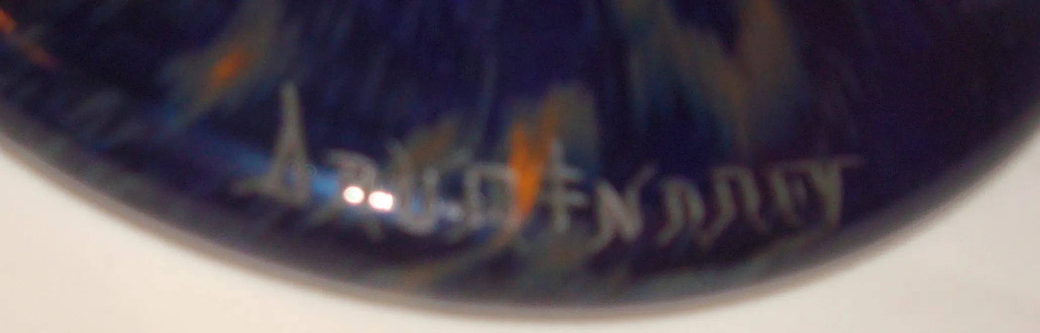 Antiguo vidrio firmado Daum Nancy con colores vibrantes en fondo oscuro.