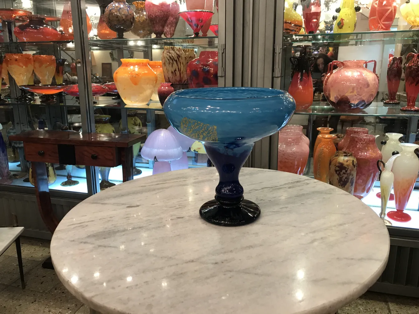 tigela de vidro azul com base preta sobre mesa de mármore