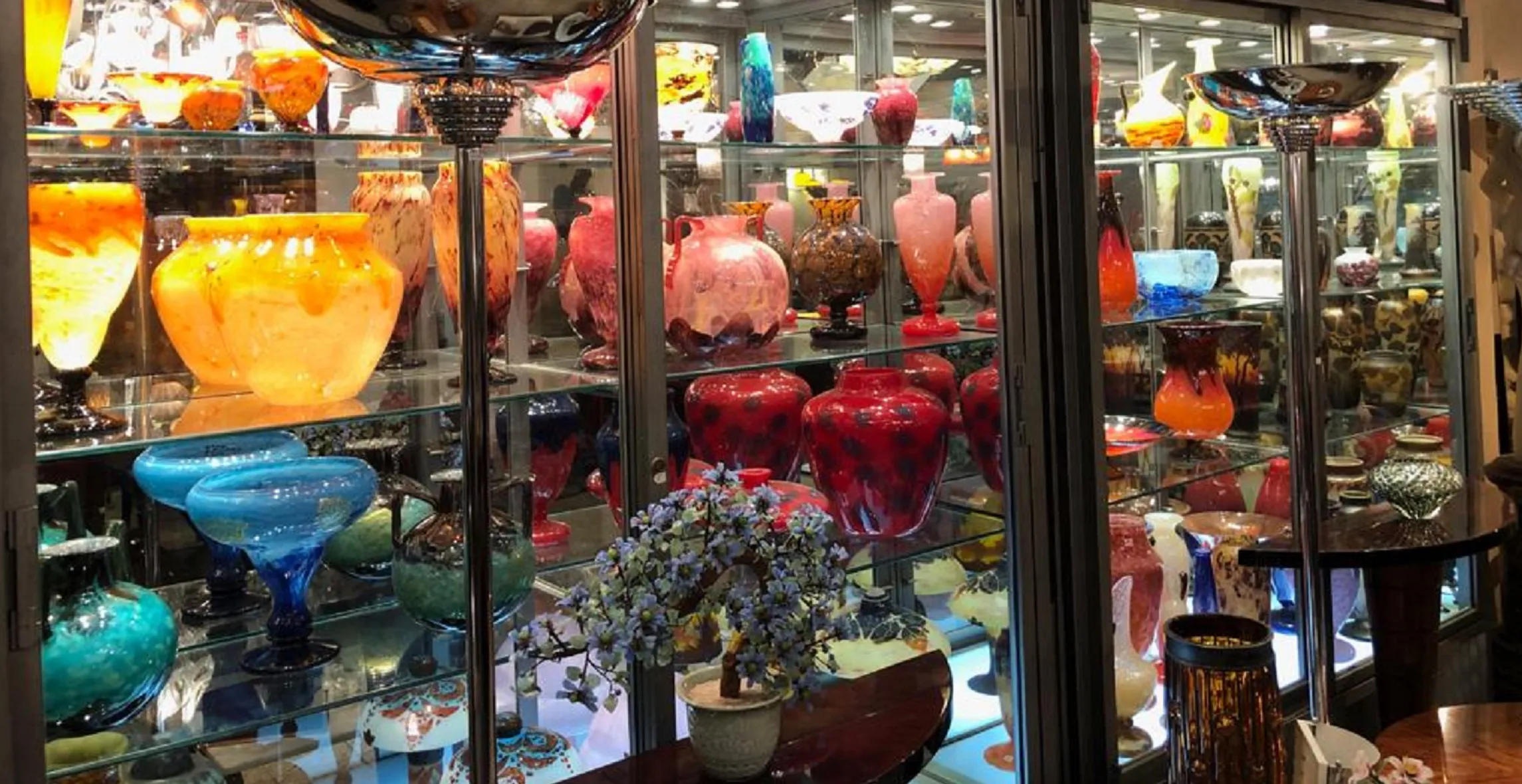 展柜中展示的古董，包含色彩鲜艳的达姆南希签名玻璃