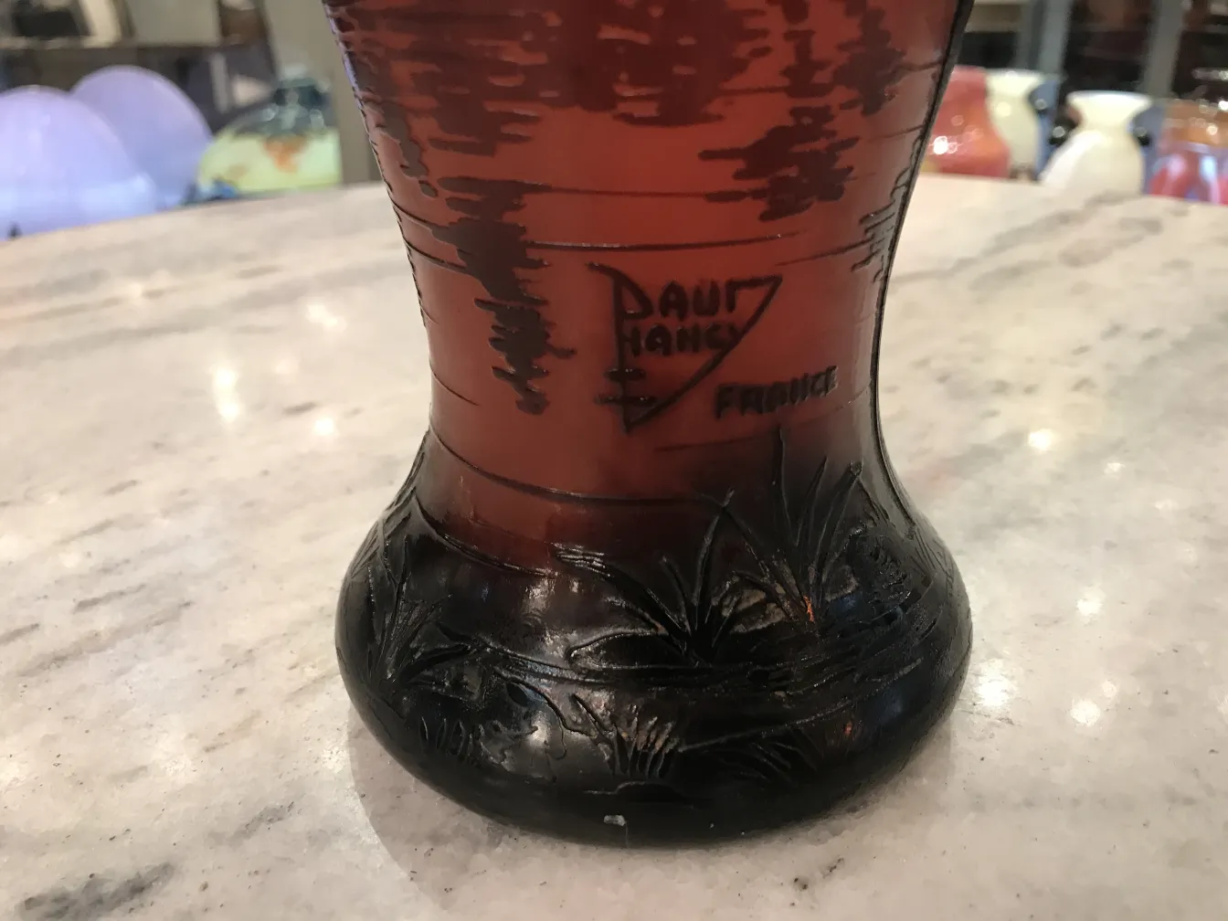 verre ancien signé Daum Nancy avec des détails noirs sur fond coloré, ambiance élégante