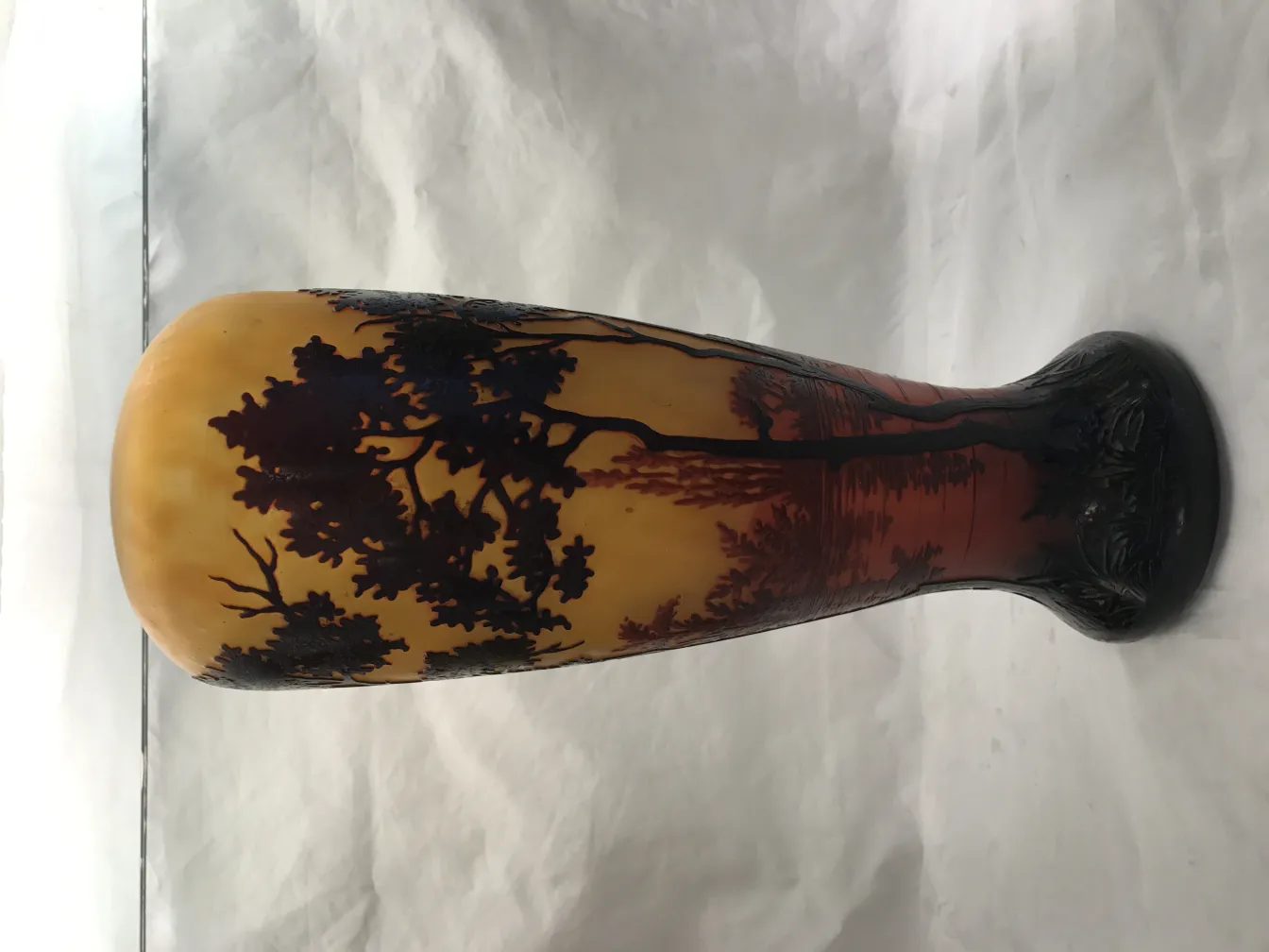 Verre ancien avec paysage en tons d'orange et noir.