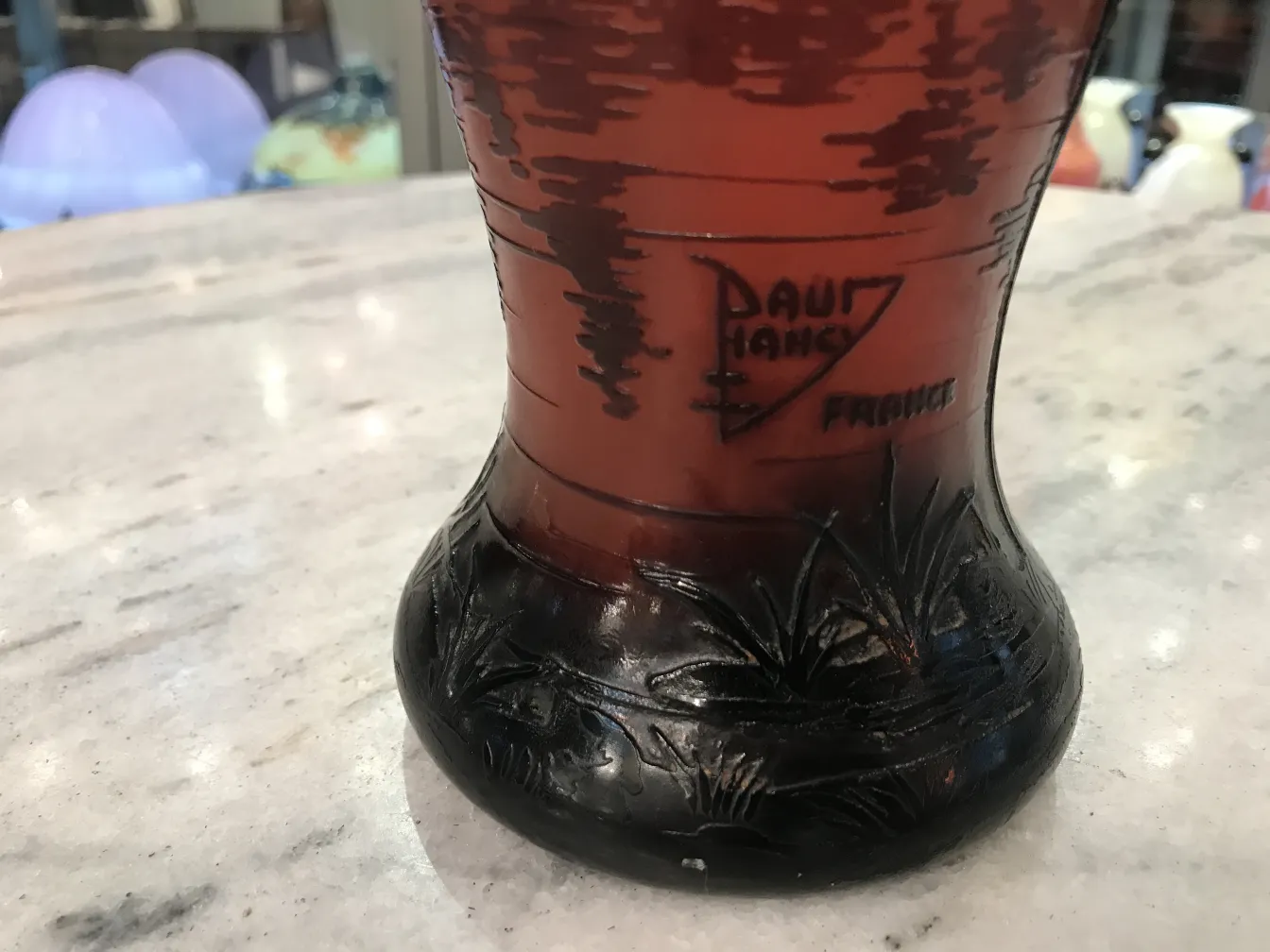 Signiertes Glas Daum Nancy mit Reliefdetails, Antiquität vor attraktivem Hintergrund.