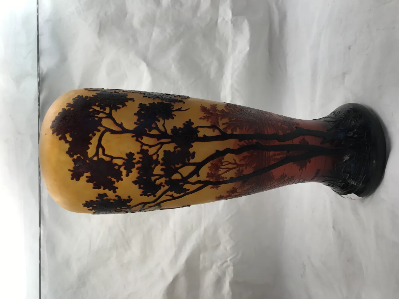 Signed glass Daum Nancy featuring dark tree landscape on light background.
