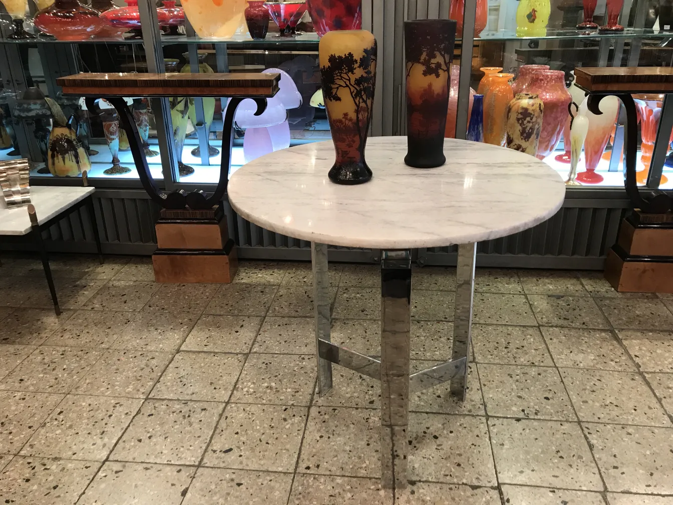 Verre signé Daum Nancy dans un cadre décoratif antique avec divers objets.