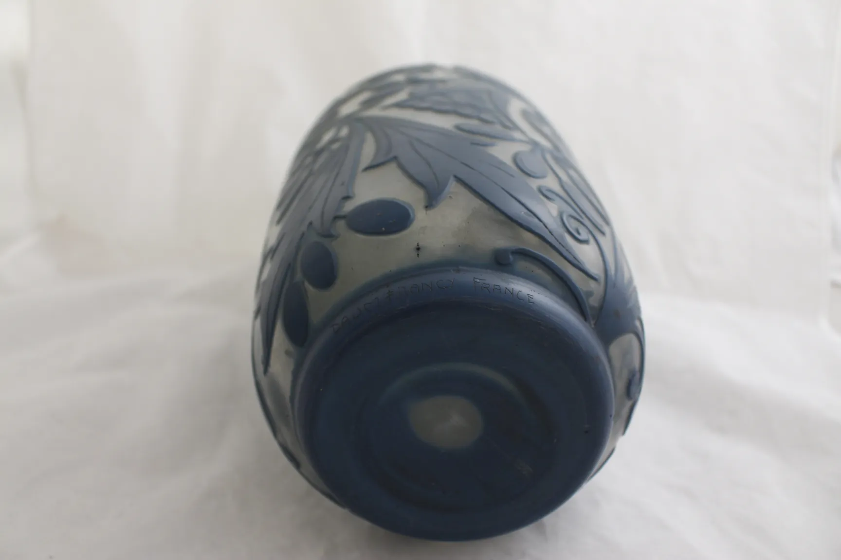 Vidrio firmado Daum Nancy con diseño floral en azul oscuro, ambiente ligero.