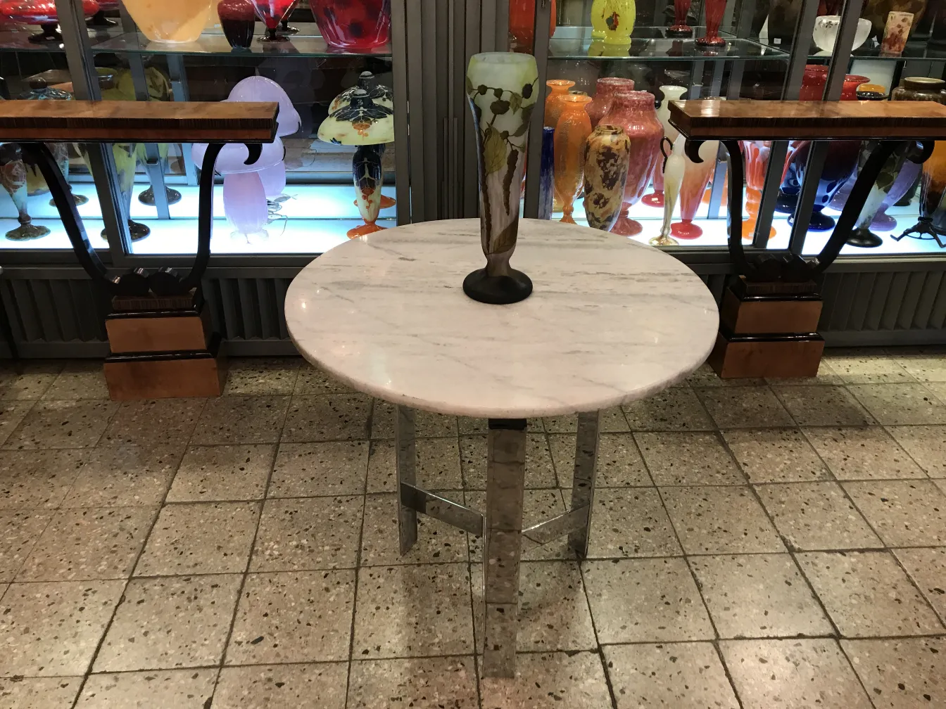 Vase en verre signé Daum Nancy exposé avec d'autres antiquités colorées