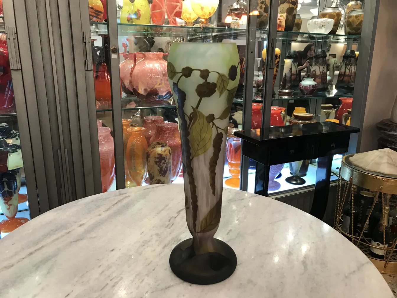 Antikes Glas mit Unterschrift, verziert mit Blättern in einer bunten Ausstellung