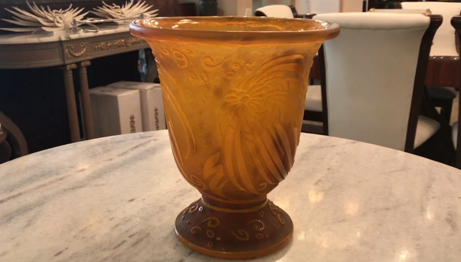 Antiquité verre daum nancy avec des gravures décoratives sur un fond subtil.