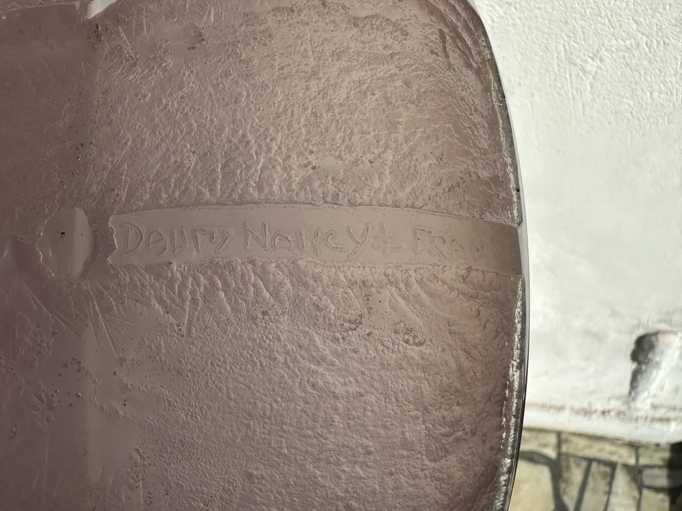 Glass item with Daum Nancy signature in neutral setting.