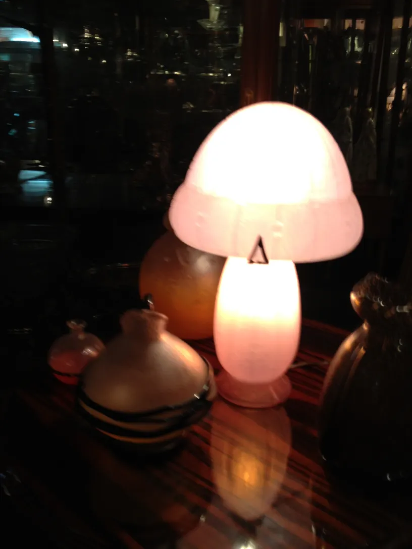 Verre signé Daum Nancy dans un contexte ancien avec d'autres objets décoratifs.