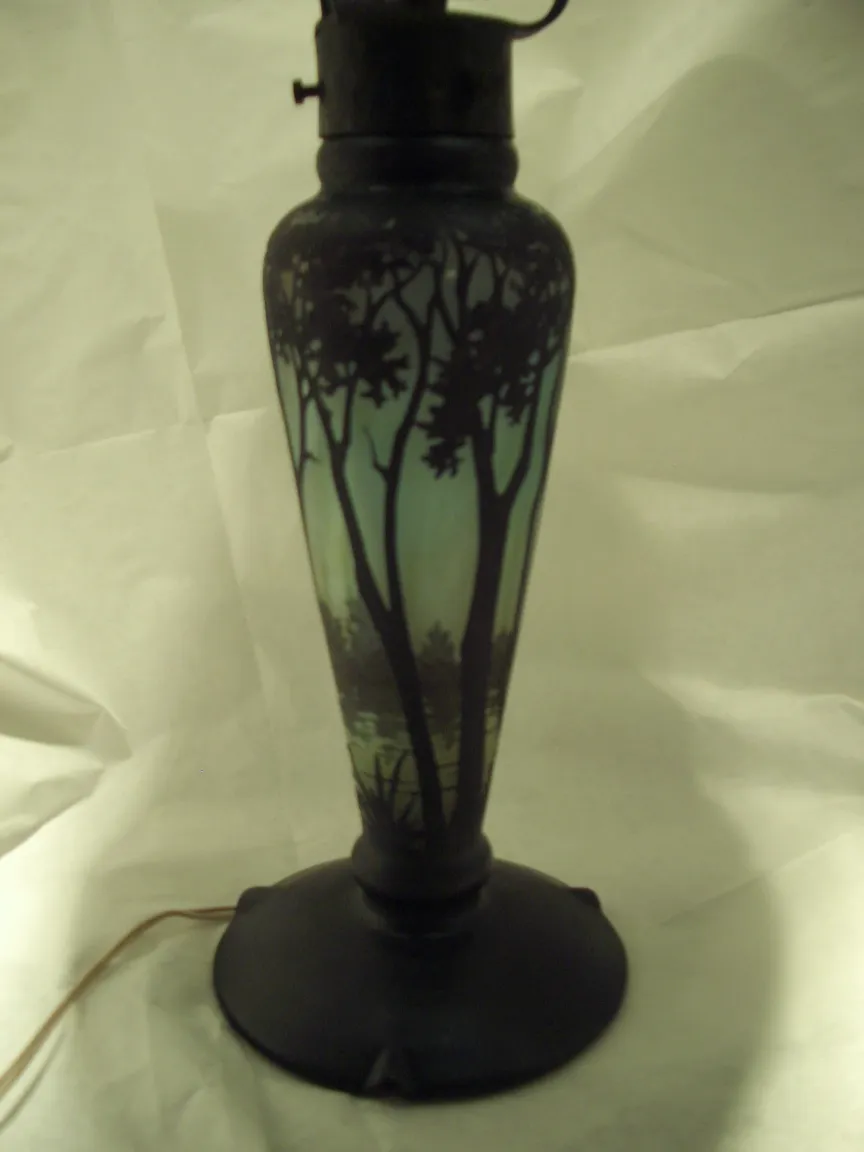 Lampada in vetro con alberi sullo sfondo, atmosfera calda.