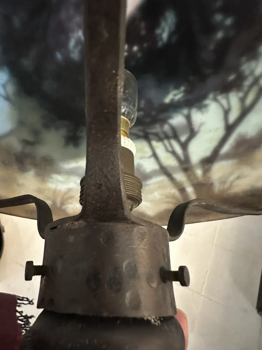 메탈 베이스와 다움 낭시의 서명이 있는 고대 램프, 배경에 풍경이 있습니다.