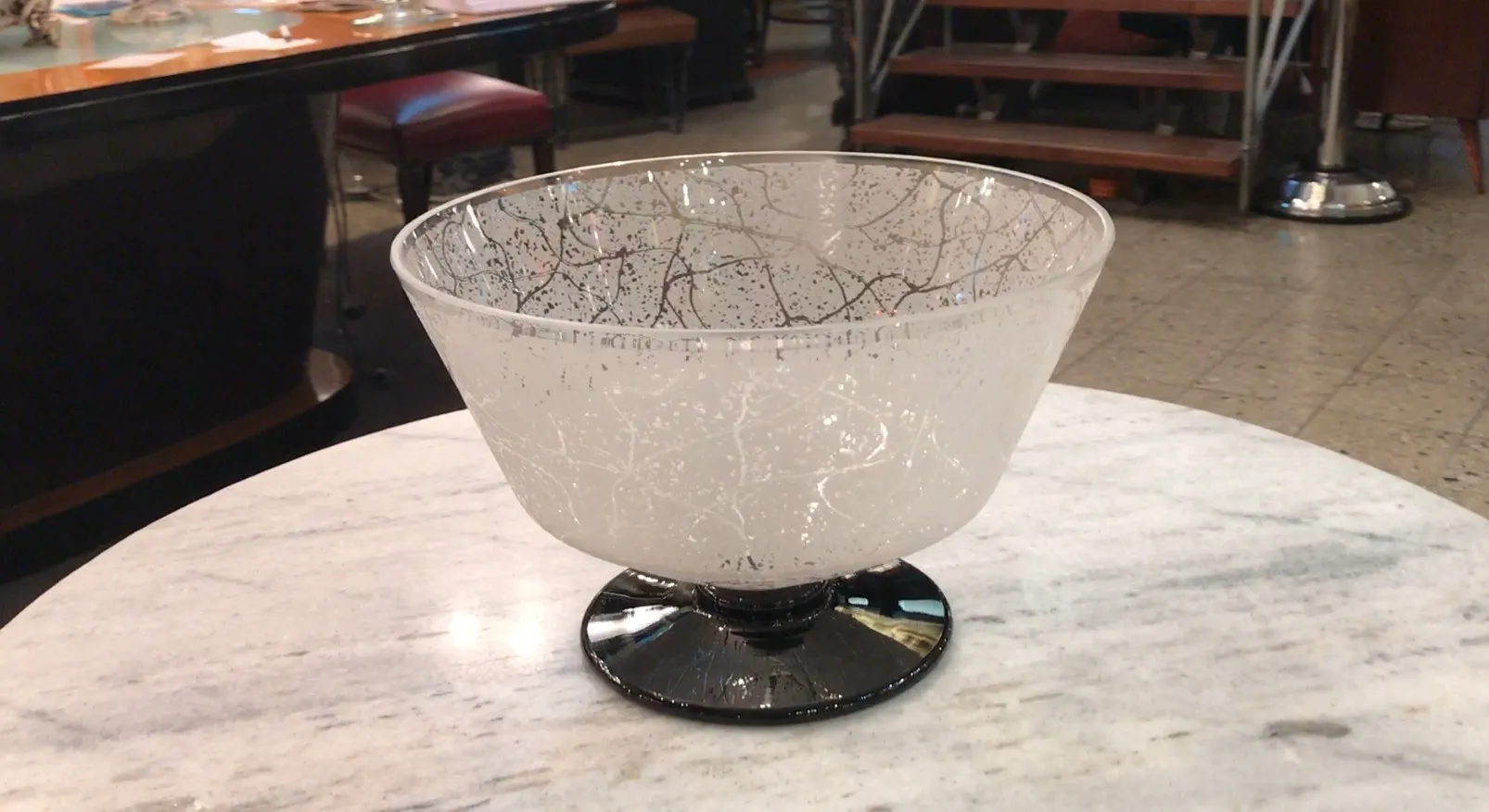 Glass bowl with white and black patterns, wooden background.