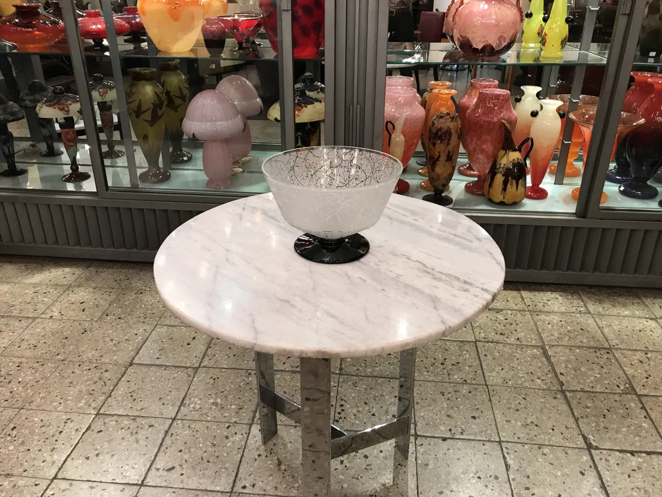 ciotola di vetro firmata daum nancy su tavolo in marmo, decorazione colorata sullo sfondo