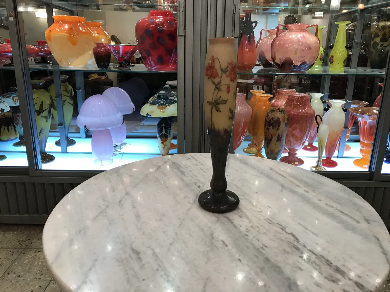 Pièce ancienne en verre avec des décorations florales, exposée.