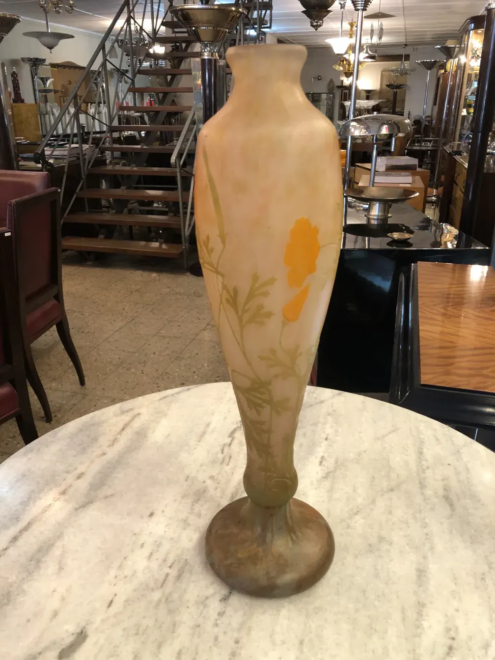 Vaso firmato Daum Nancy con disegni floreali gialli e verdi, ambiente antico.