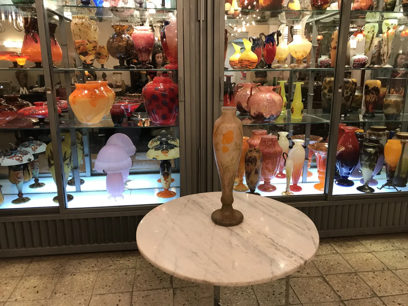 Verre signé Daum Nancy exposé dans un cadre coloré d'antiquités.