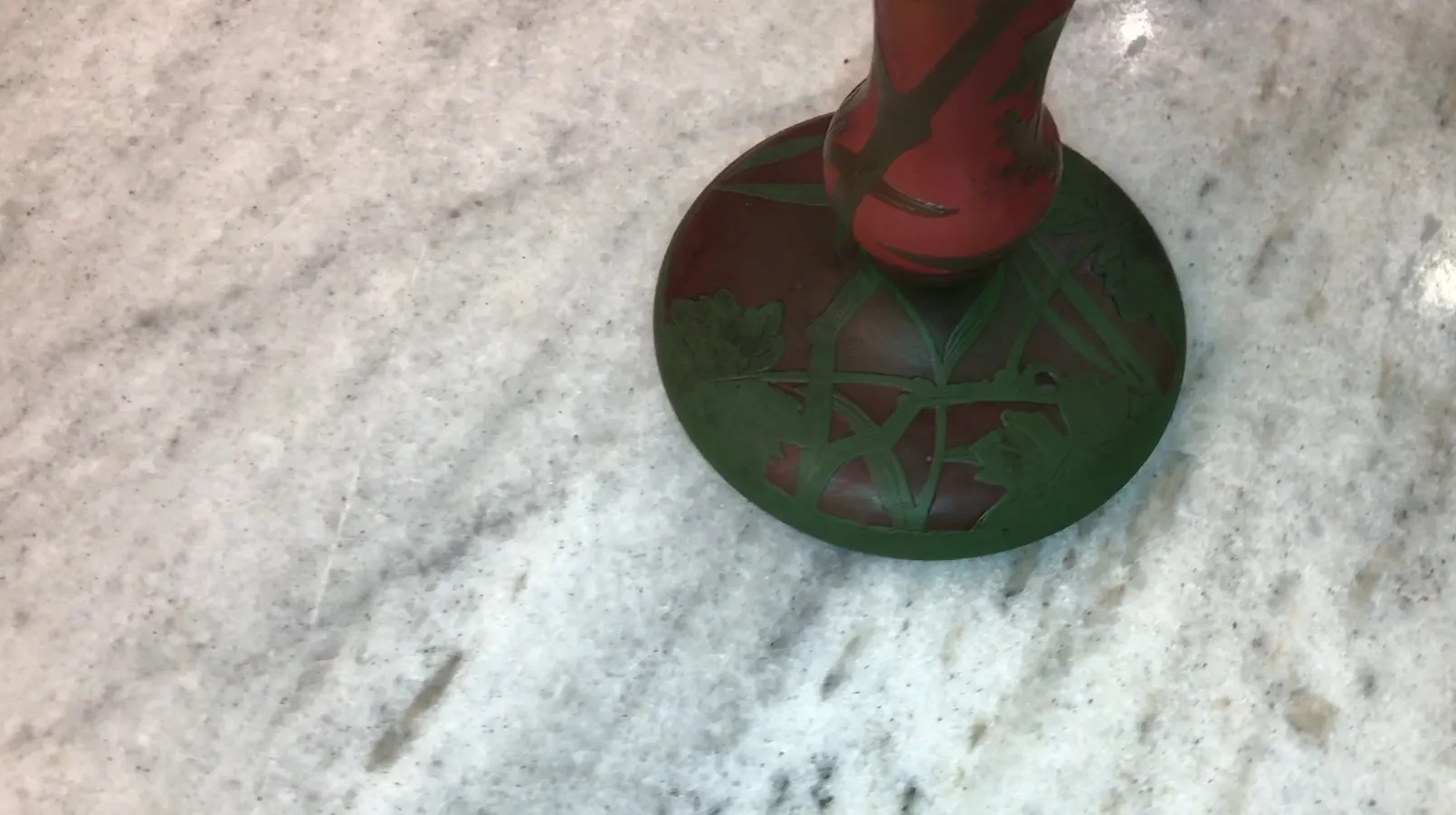 verre ancien signé daum nancy avec des détails verts sur fond rouge