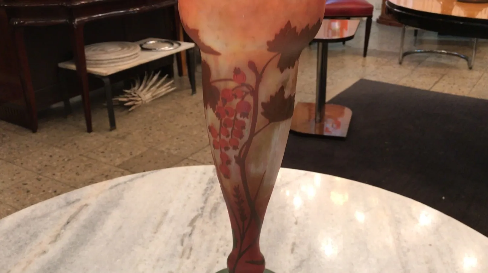 antigo vaso de vidro assinado daum nancy com decorações florais, exposto sobre uma mesa de mármore.