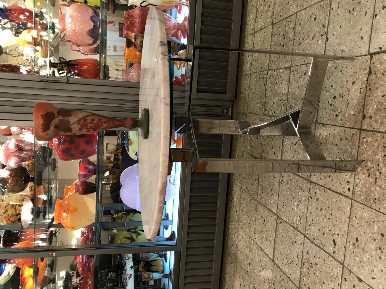 签名玻璃Daum Nancy，展示着多彩的设计和绿色底座，旁边有其他玻璃物品。