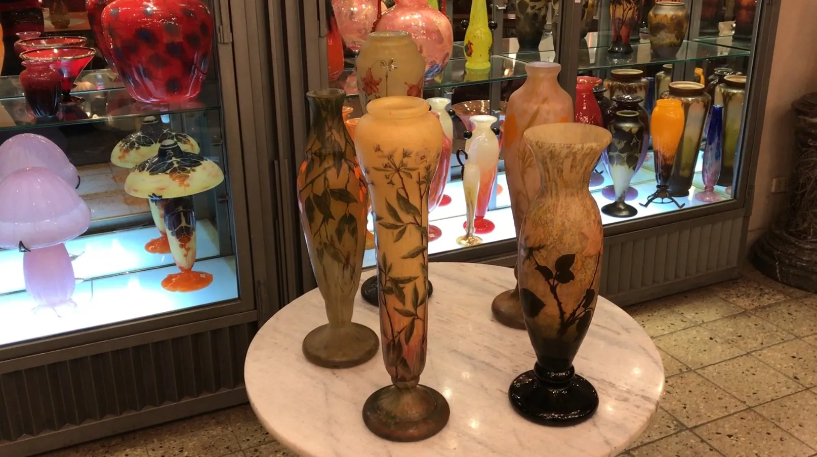 Vasos antigos de vidro assinado Daum Nancy em um ambiente elegante.