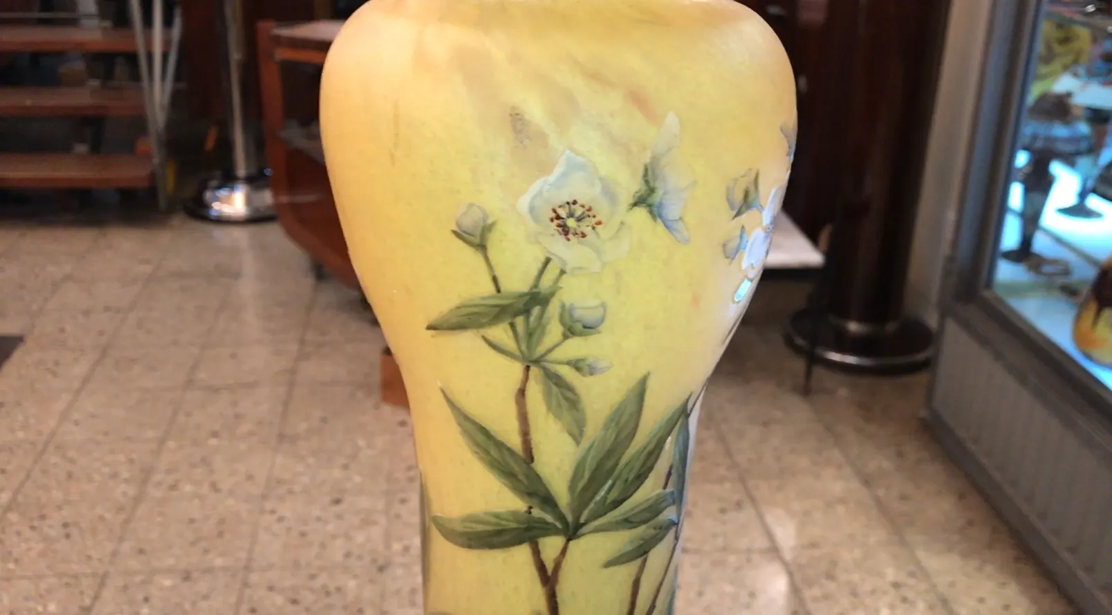 Antike Vase mit Unterschrift Daum Nancy und floralen Motiven in Gelb und Grün.