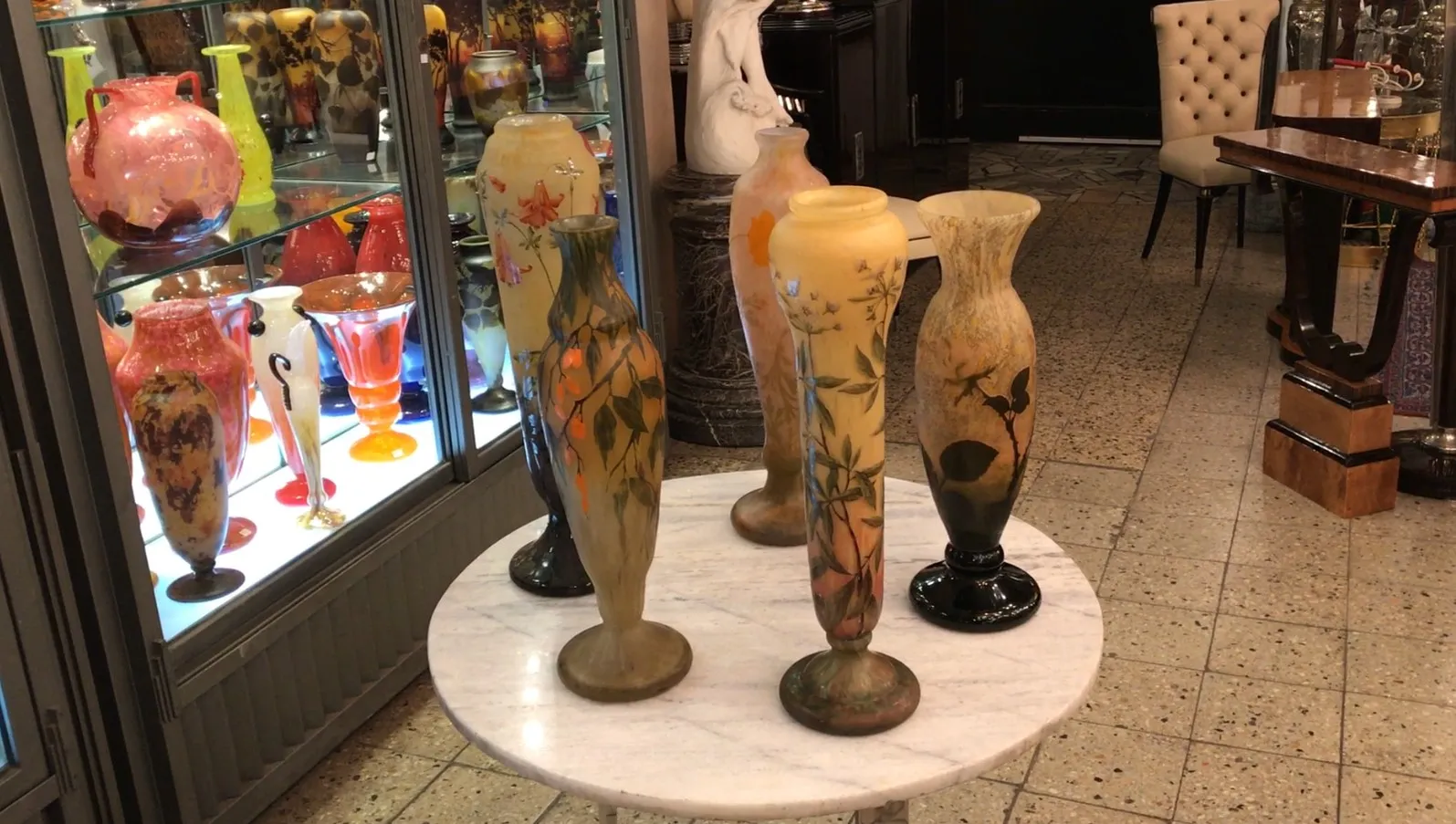 vista de colección de antigüedades con jarrones de vidrio multicolores, incluido el vidrio firmado Daum Nancy.