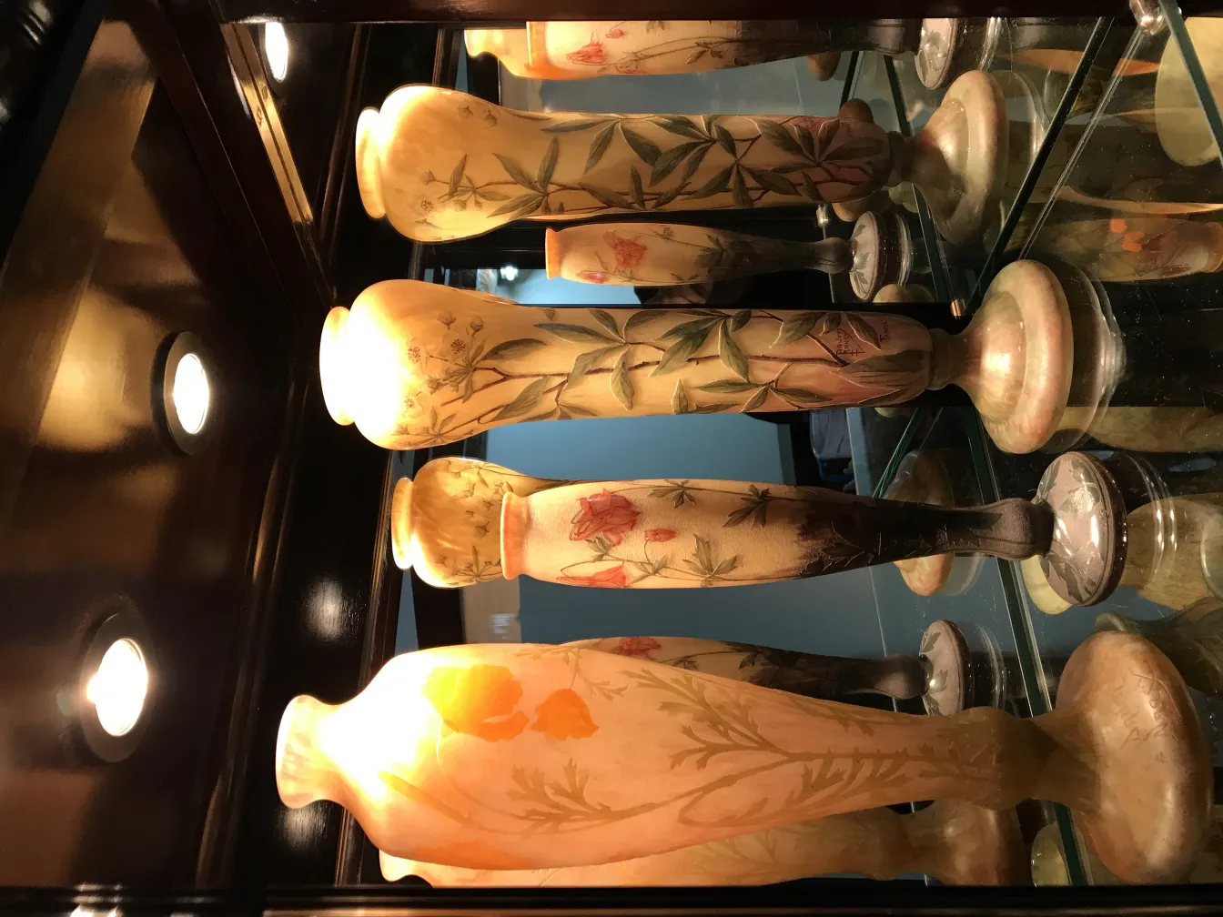 Three antique signed glass vases by Daum Nancy with floral patterns.