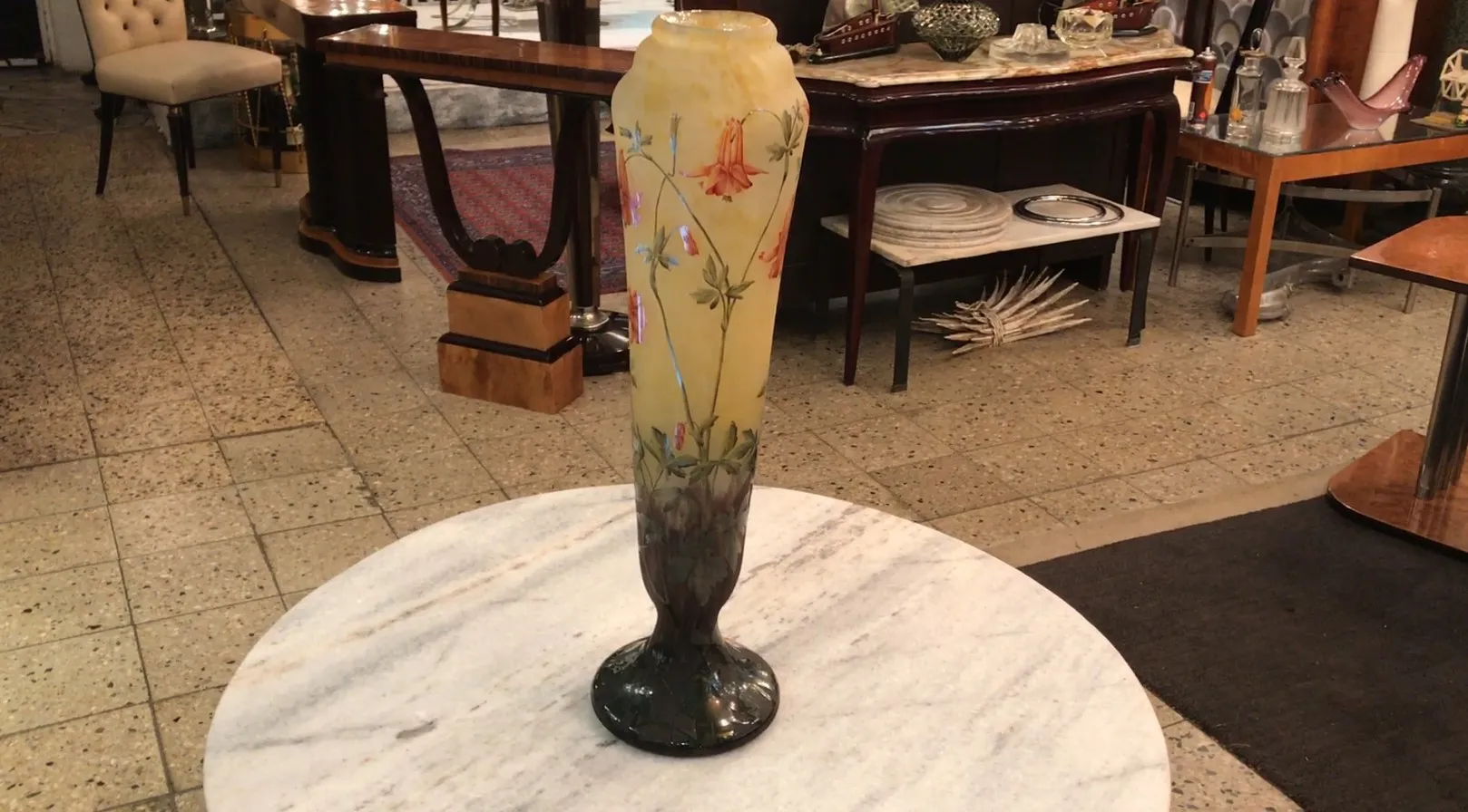 Vaso alto con diseño floral y colores cálidos en fondo