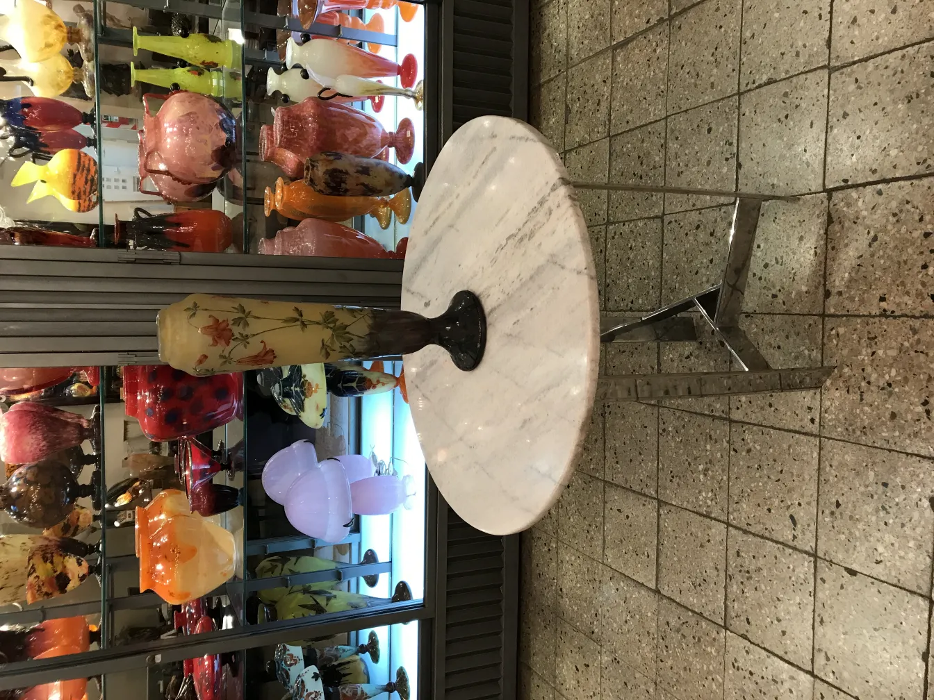 Vidrio firmado Daum Nancy expuesto en vitrinas coloridas.