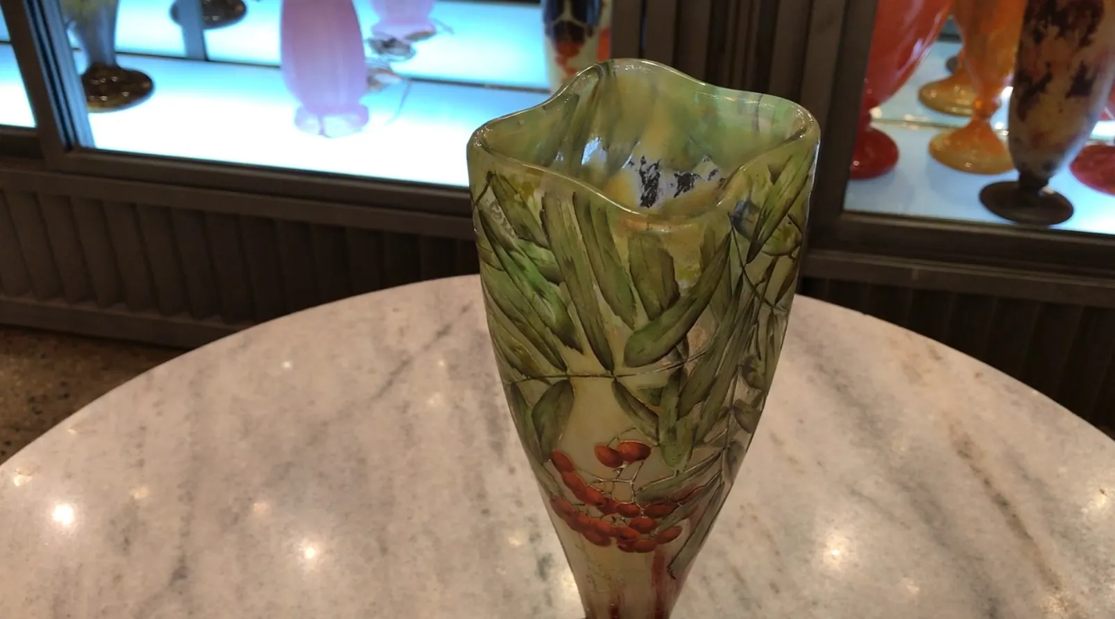 Antique decorative vase made of signed glass by Daum Nancy featuring a design of green leaves and red berries.