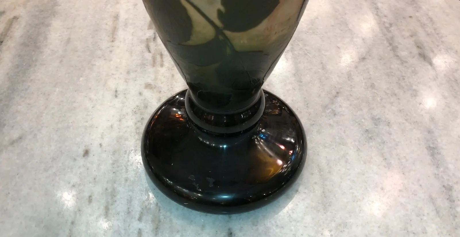 Antique signed glass from Daum Nancy with stylized base on clear surface