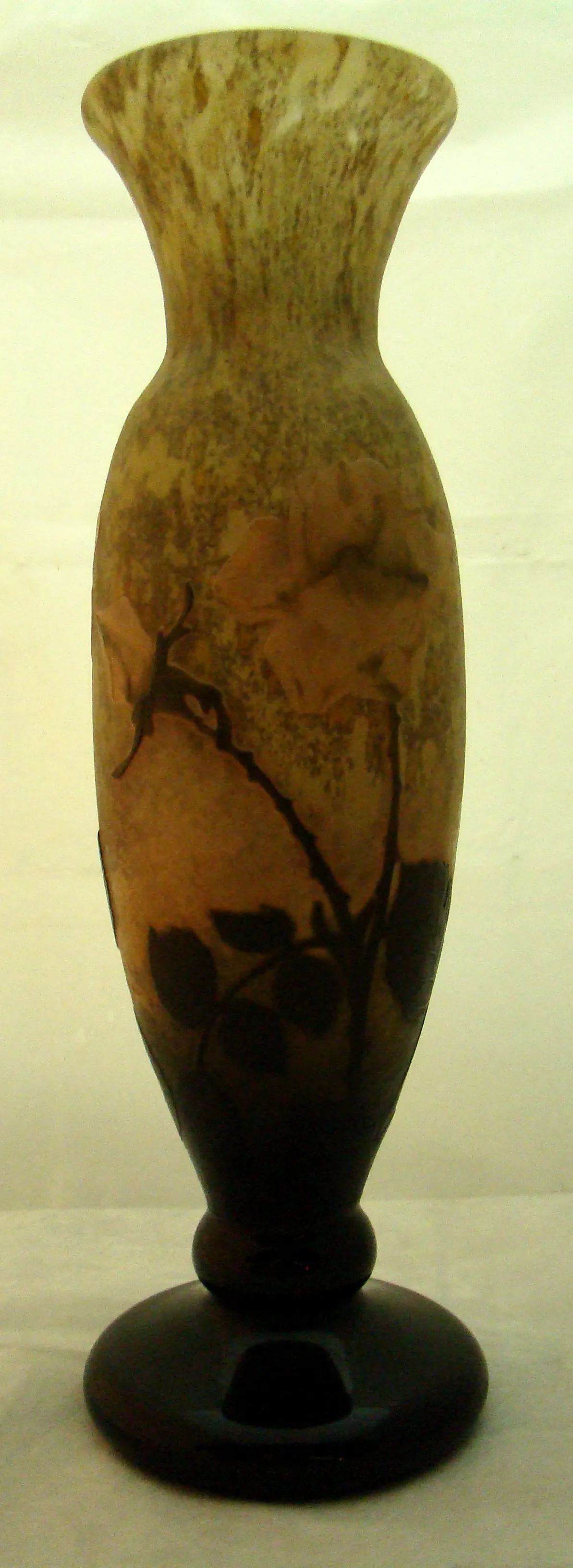 Vase de verre signé Daum Nancy avec un motif floral dans des tons bruns.