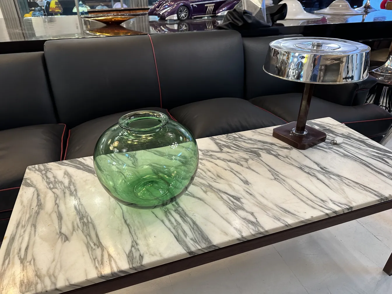 Vase en verre rond vert dans un cadre ancien.