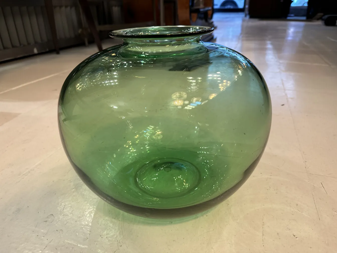Antique green signed glass, spherical shape, in a warm setting.