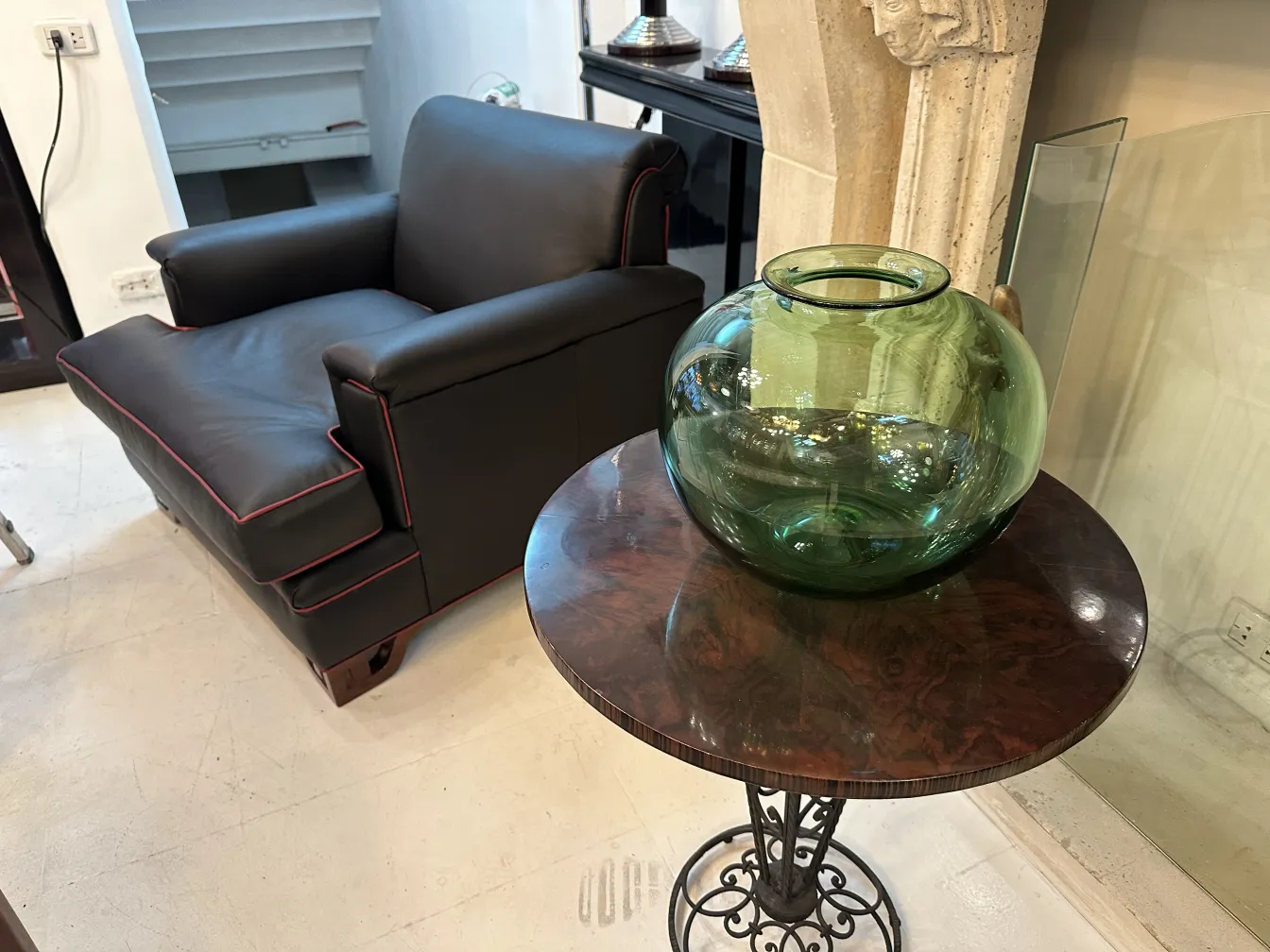 grünes rundes glas auf einem holztisch in modernem ambiente, schwarzes sofa dahinter