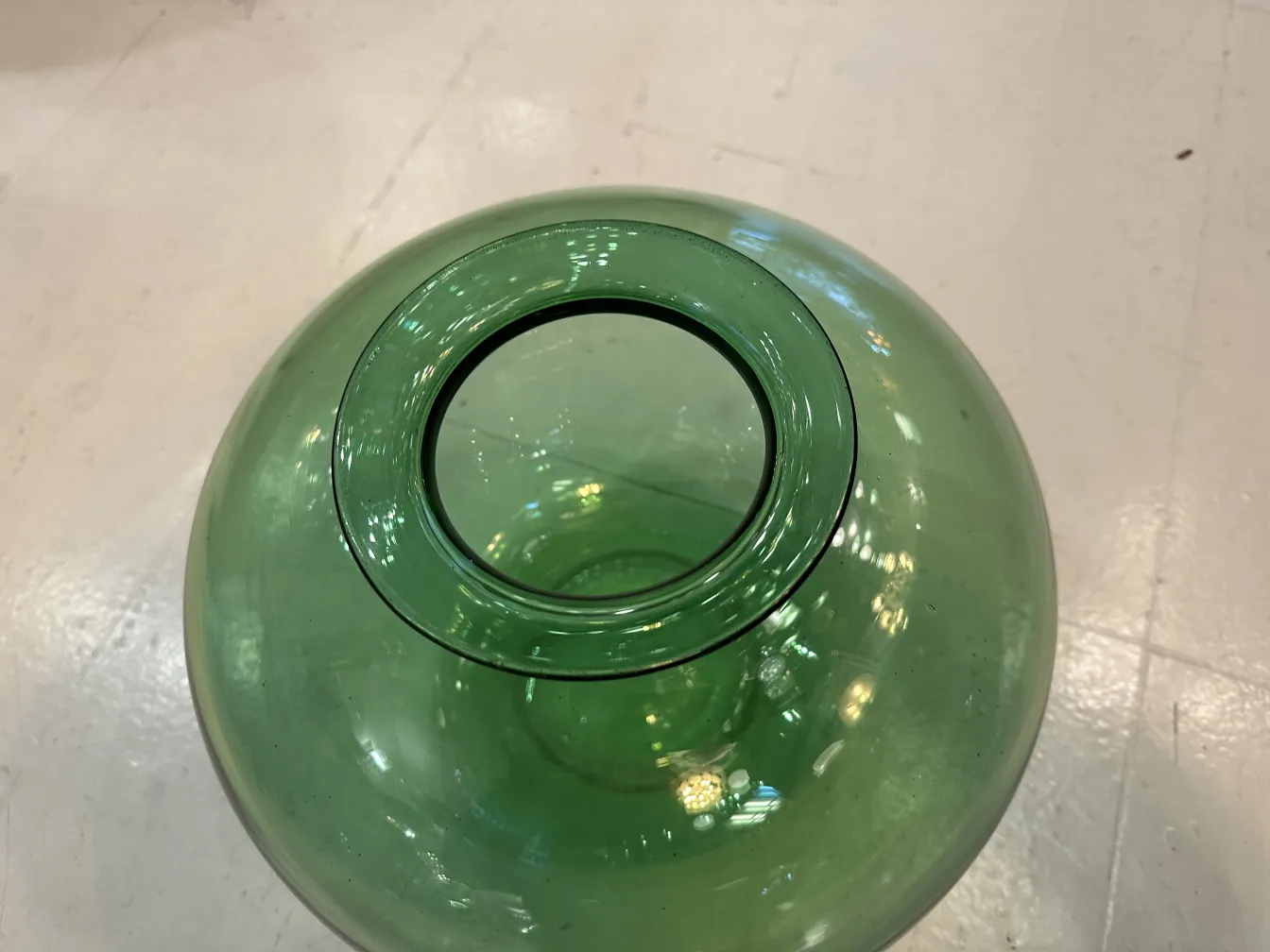 Vidro assinado de estilo antigo com formato circular e borda preta.