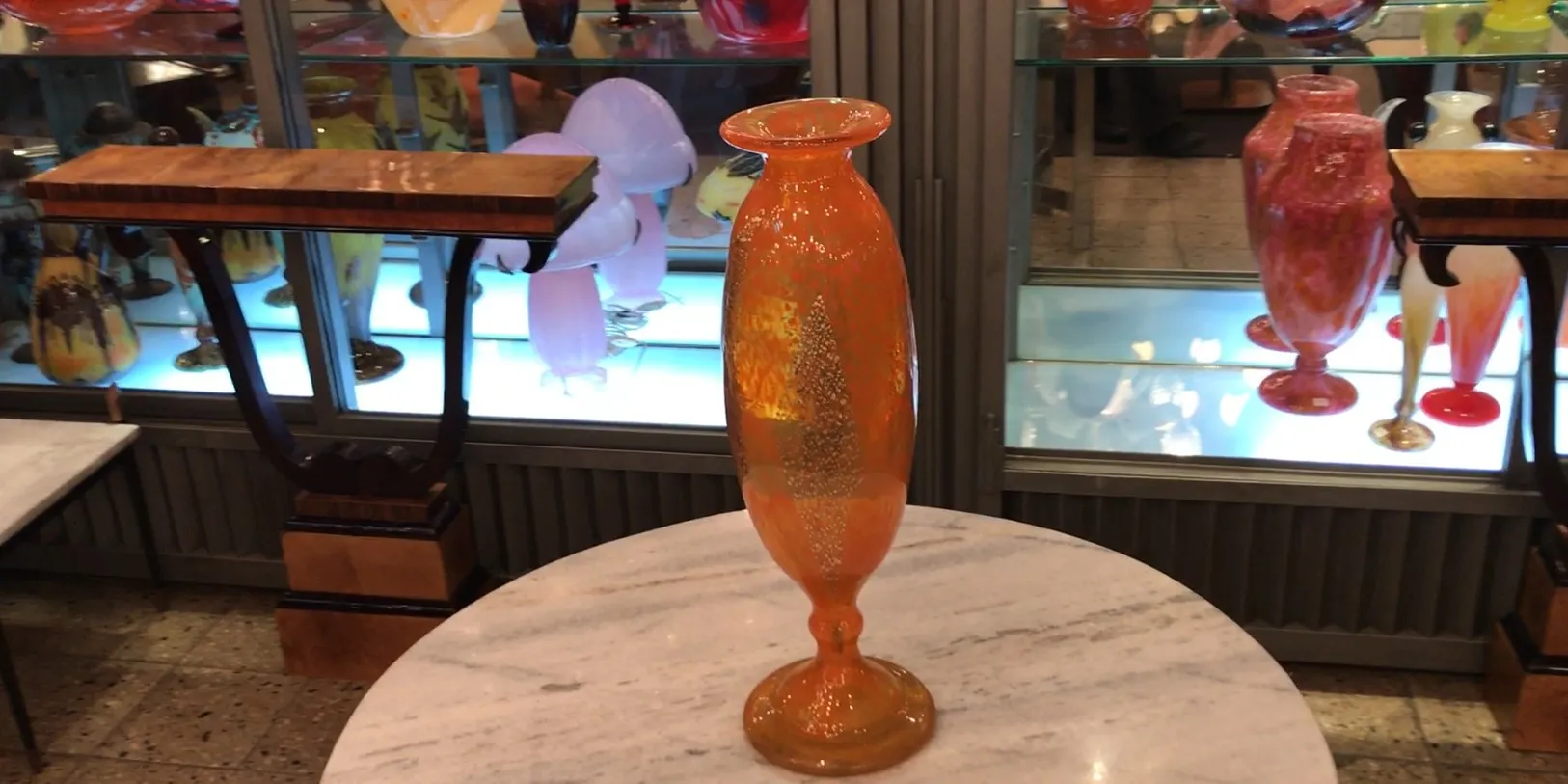 Elegante vidrio firmado con un diseño delicado, exposición en fondo iluminado.